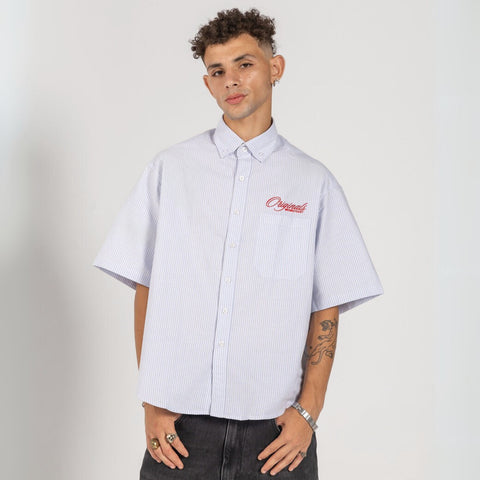 Unisex button-up shirt with a boxy fit and midi crop, featuring sailor stripes in ocean blue and white. Embroidered "Humble State of Mind" logo in burgundy red on the back and "Originals" embroidery on the front. Made from 100% thick cotton for a relaxed, summery style.