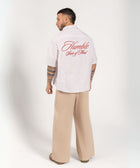 Unisex button-up shirt with a boxy fit and midi crop, featuring sailor stripes in sand beige and white. Embroidered "Humble State of Mind" logo in burgundy red on the back and "Originals" embroidery on the front. Made from 100% thick cotton for a relaxed, summery style.