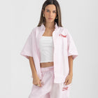 Unisex button-up shirt with a boxy fit and midi crop, featuring sailor stripes in rose pink and white. Embroidered "Humble State of Mind" logo in burgundy red on the back and "Originals" embroidery on the front. Made from 100% thick cotton for a relaxed, summery style.