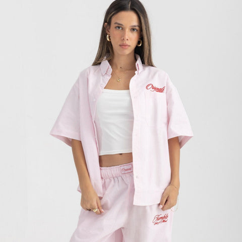 Unisex button-up shirt with a boxy fit and midi crop, featuring sailor stripes in rose pink and white. Embroidered "Humble State of Mind" logo in burgundy red on the back and "Originals" embroidery on the front. Made from 100% thick cotton for a relaxed, summery style.