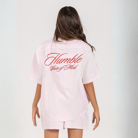 Unisex button-up shirt with a boxy fit and midi crop, featuring sailor stripes in rose pink and white. Embroidered "Humble State of Mind" logo in burgundy red on the back and "Originals" embroidery on the front. Made from 100% thick cotton for a relaxed, summery style.