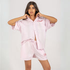 Unisex button-up shirt with a boxy fit and midi crop, featuring sailor stripes in rose pink and white. Embroidered "Humble State of Mind" logo in burgundy red on the back and "Originals" embroidery on the front. Made from 100% thick cotton for a relaxed, summery style.