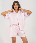 Unisex button-up shirt with a boxy fit and midi crop, featuring sailor stripes in rose pink and white. Embroidered "Humble State of Mind" logo in burgundy red on the back and "Originals" embroidery on the front. Made from 100% thick cotton for a relaxed, summery style.