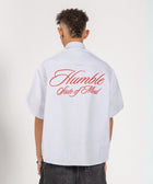 Unisex button-up shirt with a boxy fit and midi crop, featuring sailor stripes in ocean blue and white. Embroidered "Humble State of Mind" logo in burgundy red on the back and "Originals" embroidery on the front. Made from 100% thick cotton for a relaxed, summery style.