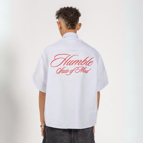 Unisex button-up shirt with a boxy fit and midi crop, featuring sailor stripes in ocean blue and white. Embroidered "Humble State of Mind" logo in burgundy red on the back and "Originals" embroidery on the front. Made from 100% thick cotton for a relaxed, summery style.