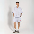 Unisex button-up shirt with a boxy fit and midi crop, featuring sailor stripes in ocean blue and white. Embroidered "Humble State of Mind" logo in burgundy red on the back and "Originals" embroidery on the front. Made from 100% thick cotton for a relaxed, summery style.