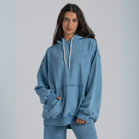 Model wearing the BROWNTOAST ASSID Hoodie in denim blue — unisex cotton-blend hoodie with relaxed fit and unique dye variations acid washed/stone washed. Each piece from the ASSID drop is one of a kind, made in Egypt through a special process for an elevated everyday look.