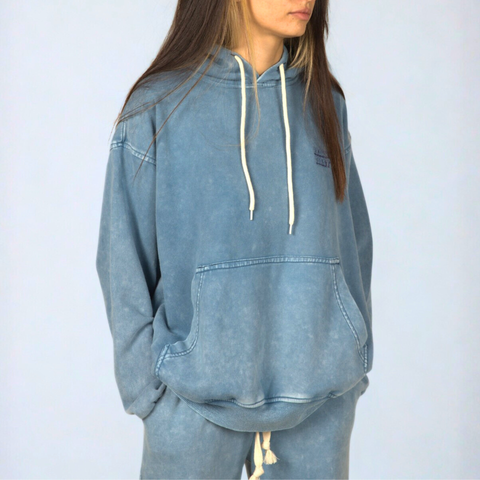 Model wearing the BROWNTOAST ASSID Hoodie in denim blue — unisex cotton-blend hoodie with relaxed fit and unique dye variations acid washed/stone washed. Each piece from the ASSID drop is one of a kind, made in Egypt through a special process for an elevated everyday look.