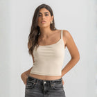 Beige ribbed spaghetti tank styled with denim jeans for a casual everyday outfit.