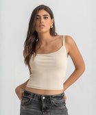 Beige ribbed spaghetti tank styled with denim jeans for a casual everyday outfit.