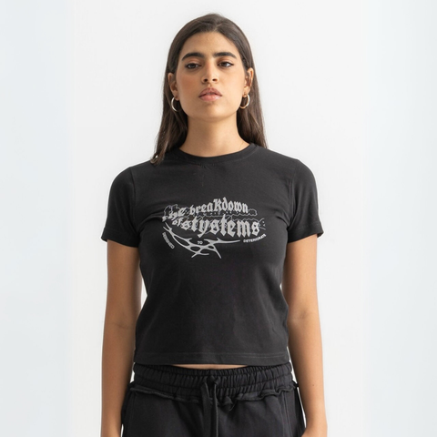 Women’s cropped black baby tee in cotton-lycra with faded grey Breakdown of Systems chest print.