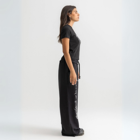 Women’s cropped black baby tee in cotton-lycra with faded grey Breakdown of Systems chest print.