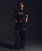 Women’s cropped black baby tee in cotton-lycra with faded grey Breakdown of Systems chest print.