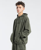  Model wearing the BROWNTOAST Core Full Zip Up Jacket from the Core Drop — a relaxed unisex hoodie with a dual zipper and adjustable hood. Made in Egypt from soft cotton, combining everyday comfort with effortless street style.
