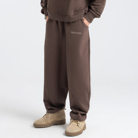 Model wearing the BROWNTOAST Core Barrel Sweats from the Core Drop — unisex cotton sweatpants in coffee brown with a relaxed barrel-shaped leg, elastic waistband, and side pockets. Made in Egypt for structured comfort and clean everyday style.