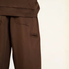 Model wearing the BROWNTOAST Core Barrel Sweats from the Core Drop — unisex cotton sweatpants in coffee brown with a relaxed barrel-shaped leg, elastic waistband, and side pockets. Made in Egypt for structured comfort and clean everyday style.