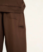 Model wearing the BROWNTOAST Core Barrel Sweats from the Core Drop — unisex cotton sweatpants in coffee brown with a relaxed barrel-shaped leg, elastic waistband, and side pockets. Made in Egypt for structured comfort and clean everyday style.