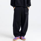 Model wearing the BROWNTOAST Core Barrel Sweats from the Core Drop — unisex cotton sweatpants in black with a relaxed barrel-shaped leg, elastic waistband, and side pockets. Made in Egypt for structured comfort and clean everyday style.