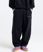 Model wearing the BROWNTOAST Core Barrel Sweats from the Core Drop — unisex cotton sweatpants in black with a relaxed barrel-shaped leg, elastic waistband, and side pockets. Made in Egypt for structured comfort and clean everyday style.