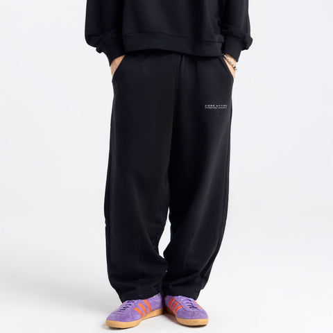 Model wearing the BROWNTOAST Core Barrel Sweats from the Core Drop — unisex cotton sweatpants in black with a relaxed barrel-shaped leg, elastic waistband, and side pockets. Made in Egypt for structured comfort and clean everyday style.