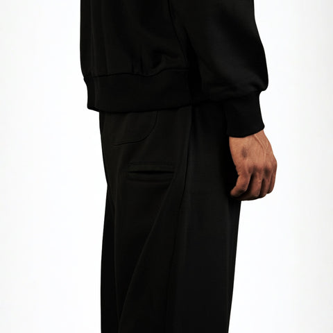 Model wearing the BROWNTOAST Core Barrel Sweats from the Core Drop — unisex cotton sweatpants in black with a relaxed barrel-shaped leg, elastic waistband, and side pockets. Made in Egypt for structured comfort and clean everyday style.