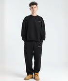 Model wearing the BROWNTOAST Core Barrel Sweats from the Core Drop — unisex cotton sweatpants in black with a relaxed barrel-shaped leg, elastic waistband, and side pockets. Made in Egypt for structured comfort and clean everyday style.