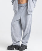 Model wearing the BROWNTOAST Core Barrel Sweats from the Core Drop — unisex cotton sweatpants in light grey with a relaxed barrel-shaped leg, elastic waistband, and side pockets. Made in Egypt for structured comfort and clean everyday style.