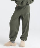 Model wearing the BROWNTOAST Core Cuffed Sweats from the Core Drop in olive green — unisex cotton sweatpants with cuffed ankles, adjustable drawstring waist, and side pockets. Made in Egypt for a relaxed, structured, and effortless everyday fit.