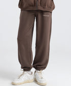 Model wearing the BROWNTOAST Core Cuffed Sweats from the Core Drop in coffee brown — unisex cotton sweatpants with cuffed ankles, adjustable drawstring waist, and side pockets. Made in Egypt for a relaxed, structured, and effortless everyday fit.