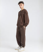 Model wearing the BROWNTOAST Core Cuffed Sweats from the Core Drop in coffee brown — unisex cotton sweatpants with cuffed ankles, adjustable drawstring waist, and side pockets. Made in Egypt for a relaxed, structured, and effortless everyday fit.