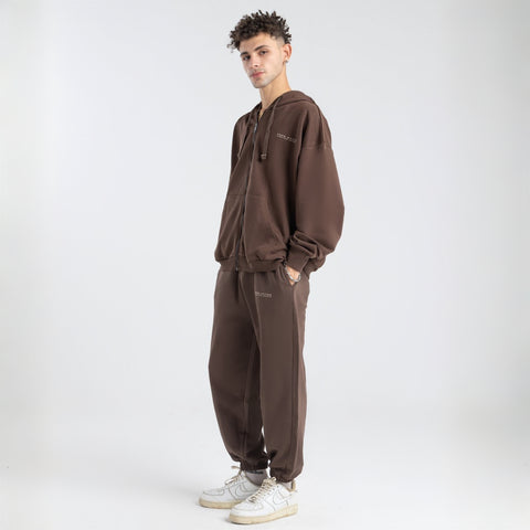 Model wearing the BROWNTOAST Core Cuffed Sweats from the Core Drop in coffee brown — unisex cotton sweatpants with cuffed ankles, adjustable drawstring waist, and side pockets. Made in Egypt for a relaxed, structured, and effortless everyday fit.