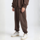 Model wearing the BROWNTOAST Core Cuffed Sweats from the Core Drop in coffee brown — unisex cotton sweatpants with cuffed ankles, adjustable drawstring waist, and side pockets. Made in Egypt for a relaxed, structured, and effortless everyday fit.