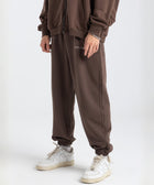 Model wearing the BROWNTOAST Core Cuffed Sweats from the Core Drop in coffee brown — unisex cotton sweatpants with cuffed ankles, adjustable drawstring waist, and side pockets. Made in Egypt for a relaxed, structured, and effortless everyday fit.