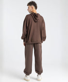 Model wearing the BROWNTOAST Core Cuffed Sweats from the Core Drop in coffee brown — unisex cotton sweatpants with cuffed ankles, adjustable drawstring waist, and side pockets. Made in Egypt for a relaxed, structured, and effortless everyday fit.