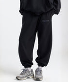 Model wearing the BROWNTOAST Core Cuffed Sweats from the Core Drop in black — unisex cotton sweatpants with cuffed ankles, adjustable drawstring waist, and side pockets. Made in Egypt for a relaxed, structured, and effortless everyday fit.