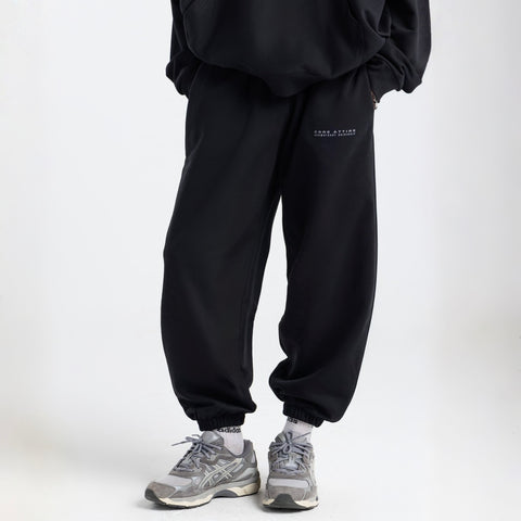 Model wearing the BROWNTOAST Core Cuffed Sweats from the Core Drop in black — unisex cotton sweatpants with cuffed ankles, adjustable drawstring waist, and side pockets. Made in Egypt for a relaxed, structured, and effortless everyday fit.