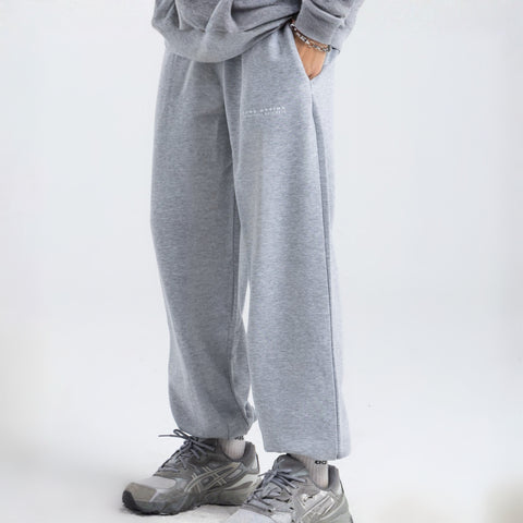 Model wearing the BROWNTOAST Core Cuffed Sweats from the Core Drop in light grey — unisex cotton sweatpants with cuffed ankles, adjustable drawstring waist, and side pockets. Made in Egypt for a relaxed, structured, and effortless everyday fit.