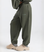 Model wearing the BROWNTOAST Core Cuffed Sweats from the Core Drop in olive green — unisex cotton sweatpants with cuffed ankles, adjustable drawstring waist, and side pockets. Made in Egypt for a relaxed, structured, and effortless everyday fit.
