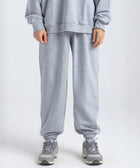 Model wearing the BROWNTOAST Core Cuffed Sweats from the Core Drop in light grey — unisex cotton sweatpants with cuffed ankles, adjustable drawstring waist, and side pockets. Made in Egypt for a relaxed, structured, and effortless everyday fit.