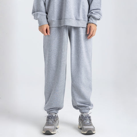 Model wearing the BROWNTOAST Core Cuffed Sweats from the Core Drop in light grey — unisex cotton sweatpants with cuffed ankles, adjustable drawstring waist, and side pockets. Made in Egypt for a relaxed, structured, and effortless everyday fit.