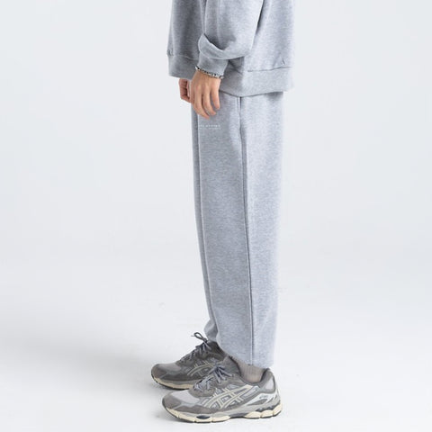 Model wearing the BROWNTOAST Core Cuffed Sweats from the Core Drop in light grey — unisex cotton sweatpants with cuffed ankles, adjustable drawstring waist, and side pockets. Made in Egypt for a relaxed, structured, and effortless everyday fit.