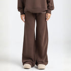 Model wearing the BROWNTOAST Core Flared Sweats from the Core Drop — women’s cotton-lycra flared sweatpants with a mid-rise waist, adjustable drawstring, and subtle seam detailing. Made in Egypt for a soft, flattering, and effortless everyday look. In coffee brown color.