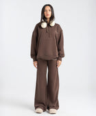 Model wearing the BROWNTOAST Core Flared Sweats from the Core Drop — women’s cotton-lycra flared sweatpants with a mid-rise waist, adjustable drawstring, and subtle seam detailing. Made in Egypt for a soft, flattering, and effortless everyday look. In coffee brown color.