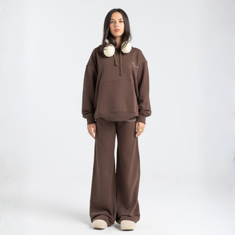 Model wearing the BROWNTOAST Core Flared Sweats from the Core Drop — women’s cotton-lycra flared sweatpants with a mid-rise waist, adjustable drawstring, and subtle seam detailing. Made in Egypt for a soft, flattering, and effortless everyday look. In coffee brown color.