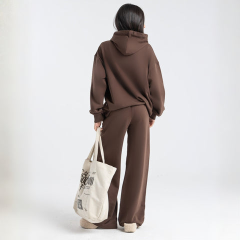 Model wearing the BROWNTOAST Core Flared Sweats from the Core Drop — women’s cotton-lycra flared sweatpants with a mid-rise waist, adjustable drawstring, and subtle seam detailing. Made in Egypt for a soft, flattering, and effortless everyday look. In coffee brown color.