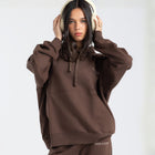 Model wearing the BROWNTOAST Core Hoodie from the Core Drop in coffee brown — a relaxed unisex hoodie with an adjustable drawstring hood, kangaroo pocket, and front silk-screen print. Made in Egypt from a soft cotton blend for an elevated everyday look.