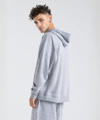 Model wearing the BROWNTOAST Core Hoodie from the Core Drop in light grey— a relaxed unisex hoodie with an adjustable drawstring hood, kangaroo pocket, and front silk-screen print. Made in Egypt from a soft cotton blend for an elevated everyday look.
