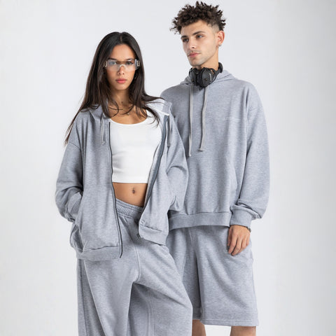 Model wearing the BROWNTOAST Core Hoodie from the Core Drop in light grey— a relaxed unisex hoodie with an adjustable drawstring hood, kangaroo pocket, and front silk-screen print. Made in Egypt from a soft cotton blend for an elevated everyday look.