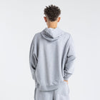 Model wearing the BROWNTOAST Core Hoodie from the Core Drop in light grey— a relaxed unisex hoodie with an adjustable drawstring hood, kangaroo pocket, and front silk-screen print. Made in Egypt from a soft cotton blend for an elevated everyday look.