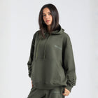 Model wearing the BROWNTOAST Core Hoodie from the Core Drop in olive green— a relaxed unisex hoodie with an adjustable drawstring hood, kangaroo pocket, and front silk-screen print. Made in Egypt from a soft cotton blend for an elevated everyday look.